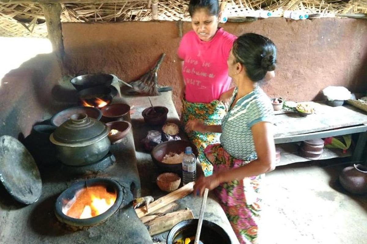 two women are cooking in an outdoor oven