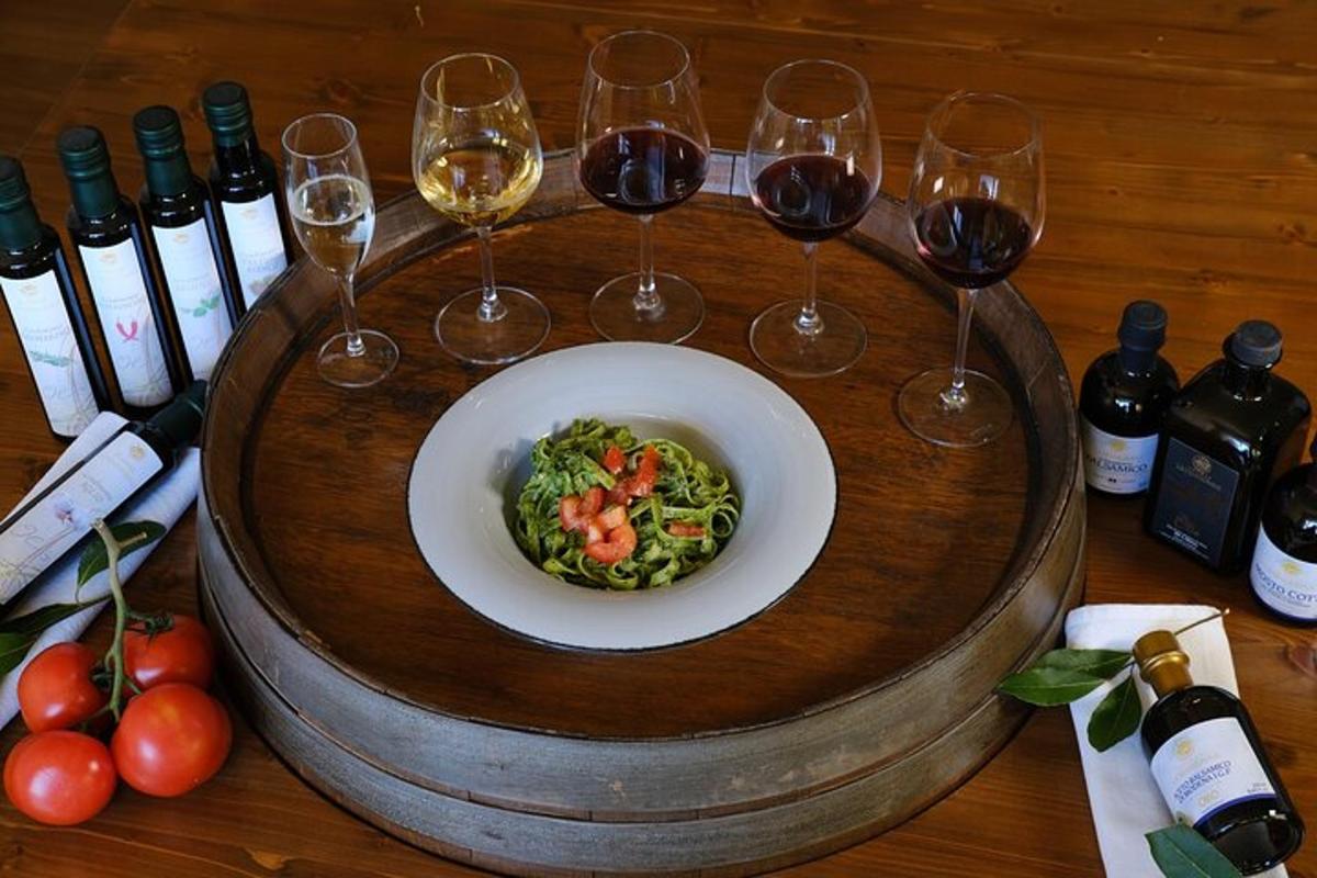 un tavolo con un piatto di pasta e bicchieri di vino