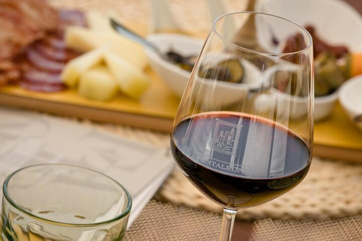 un bicchiere di vino rosso accanto a un piatto di cibo