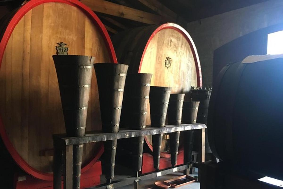 un gruppo di botti di vino e vasi su uno scaffale