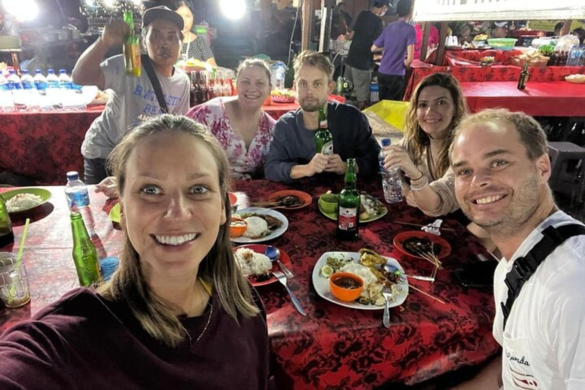 a group of people sitting at a table with food