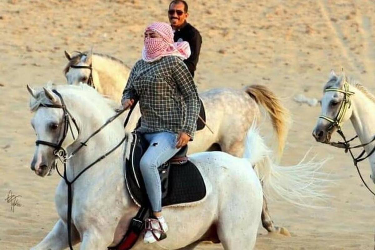 una donna che cavalca un cavallo bianco nel deserto