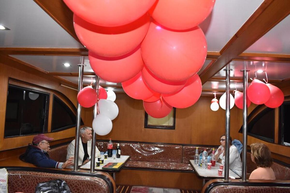 sekumpulan orang duduk di bar dengan belon merah dan putih
