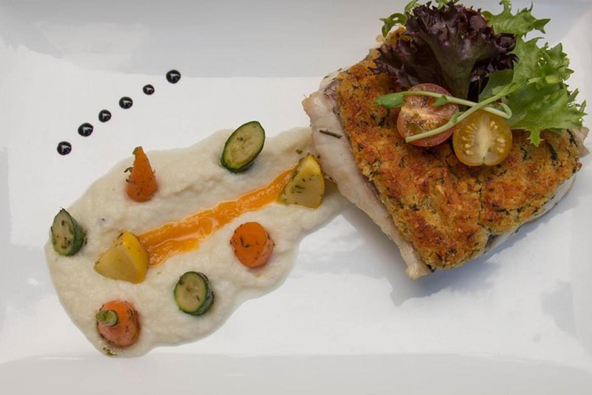 Un plato blanco con un trozo de comida y un pescado.