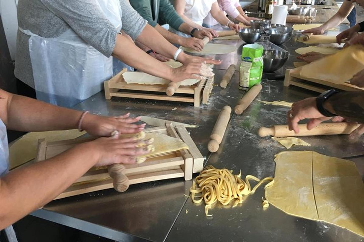 en gruppe mennesker som lager pasta på kjøkkenet