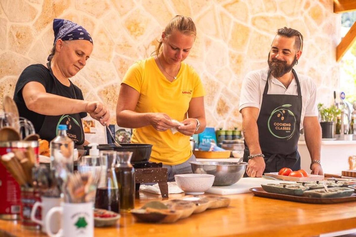 tres persones dempeus a la cuina preparant menjar