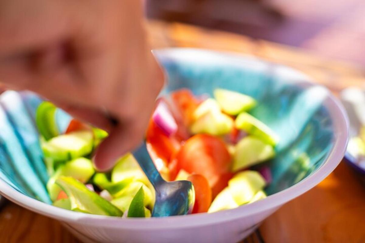 seseorang makan semangkuk buah dengan sudu