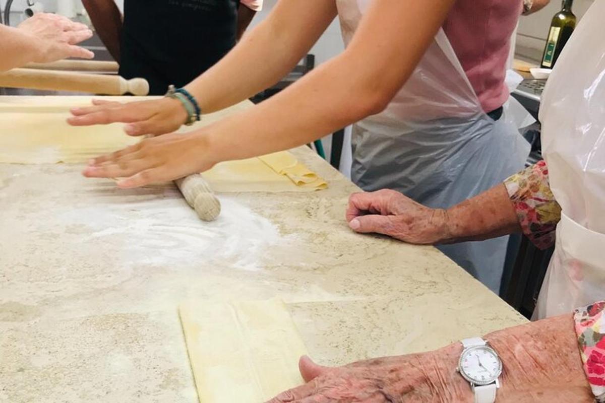 um grupo de pessoas amassando massa sobre uma mesa