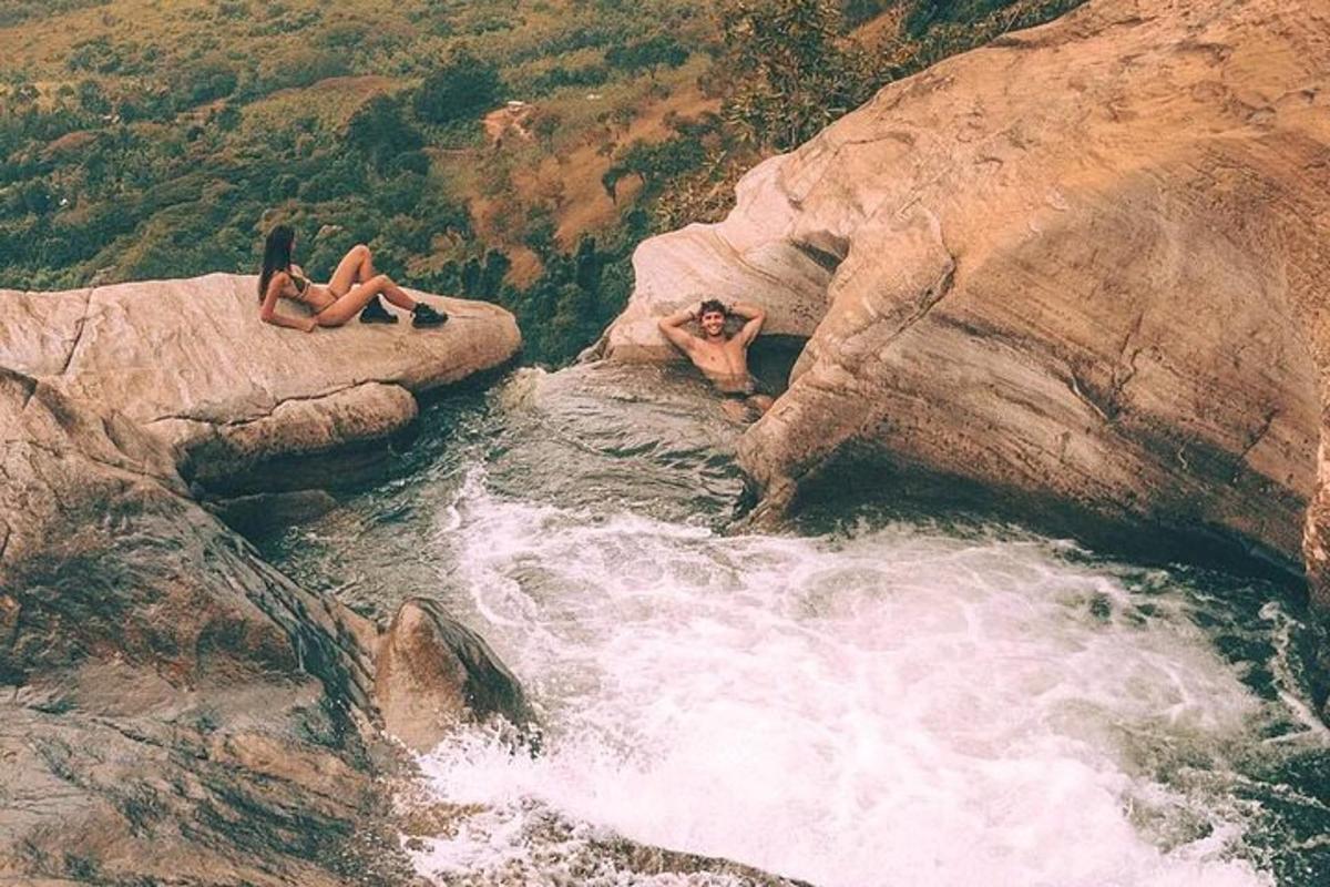 un paio di persone sedute sulle rocce nell'acqua