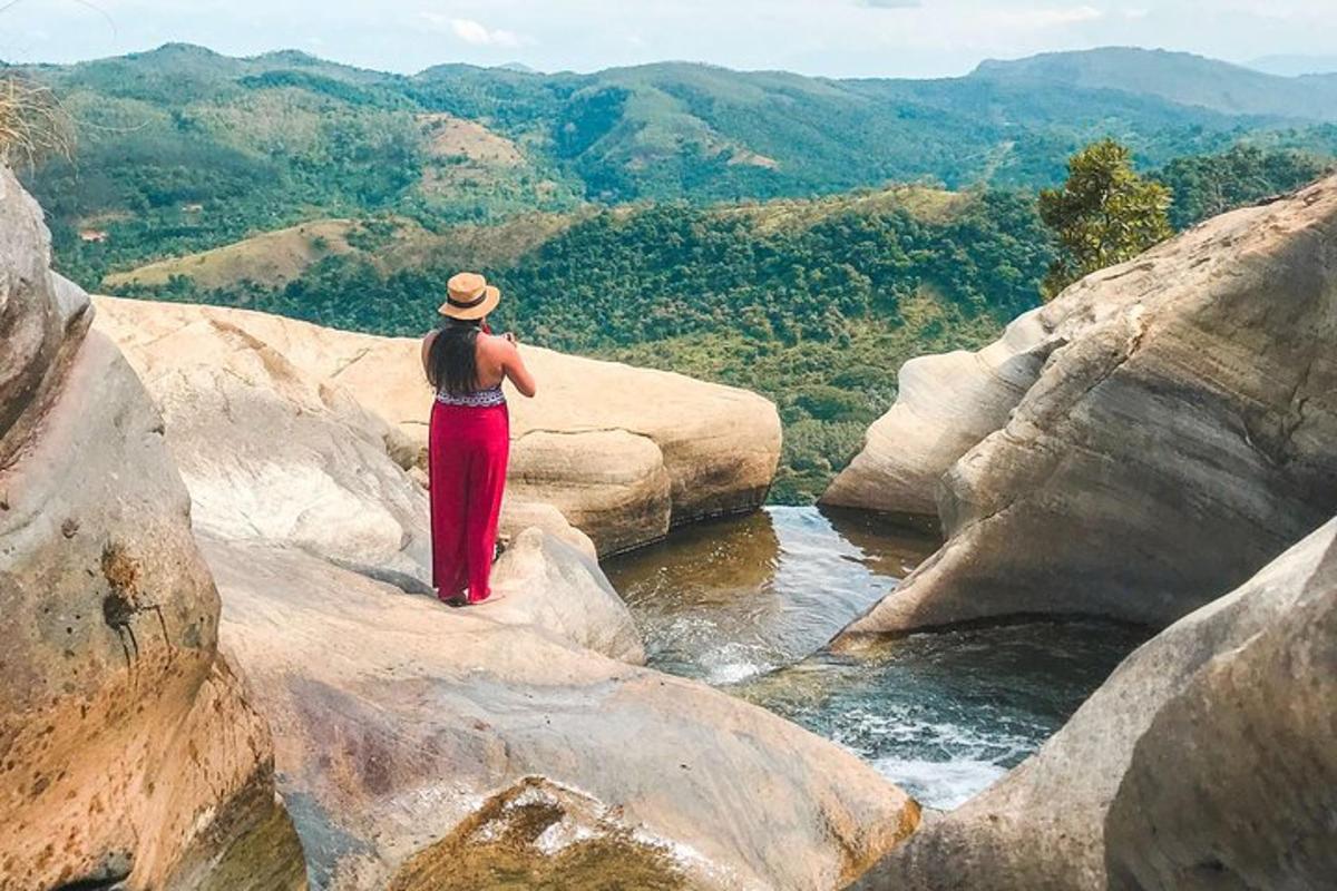 žena stojící na skalách a dívající se na řeku