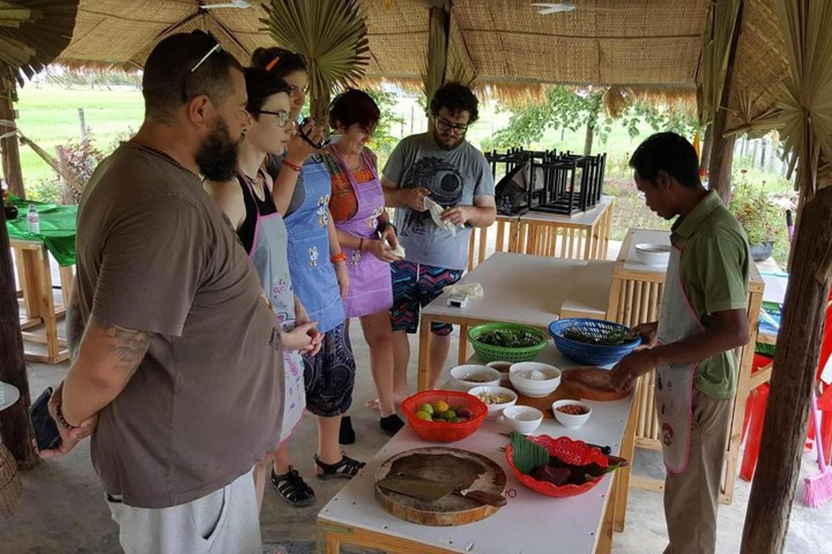 sekumpulan orang berdiri di sekeliling meja dengan makanan
