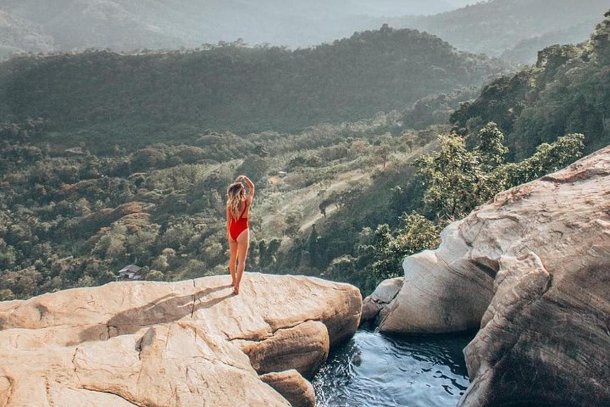 una donna in piedi in cima a una roccia nell'acqua