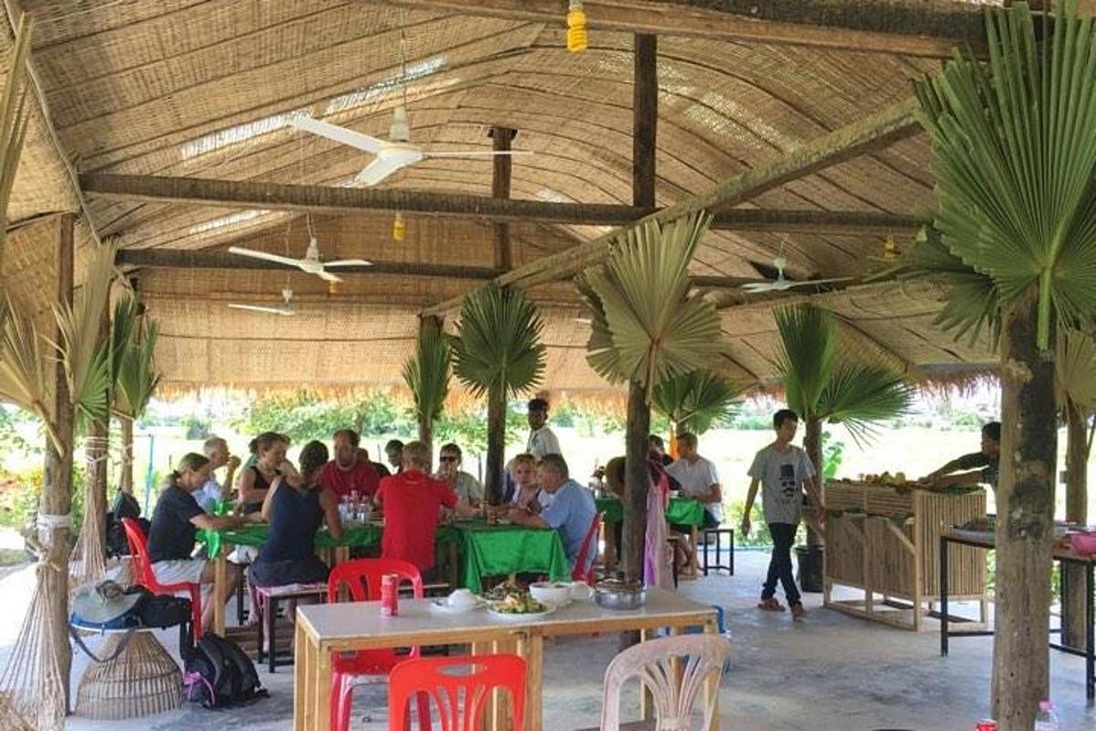 egy csoport ember ül asztaloknál egy pavilonban