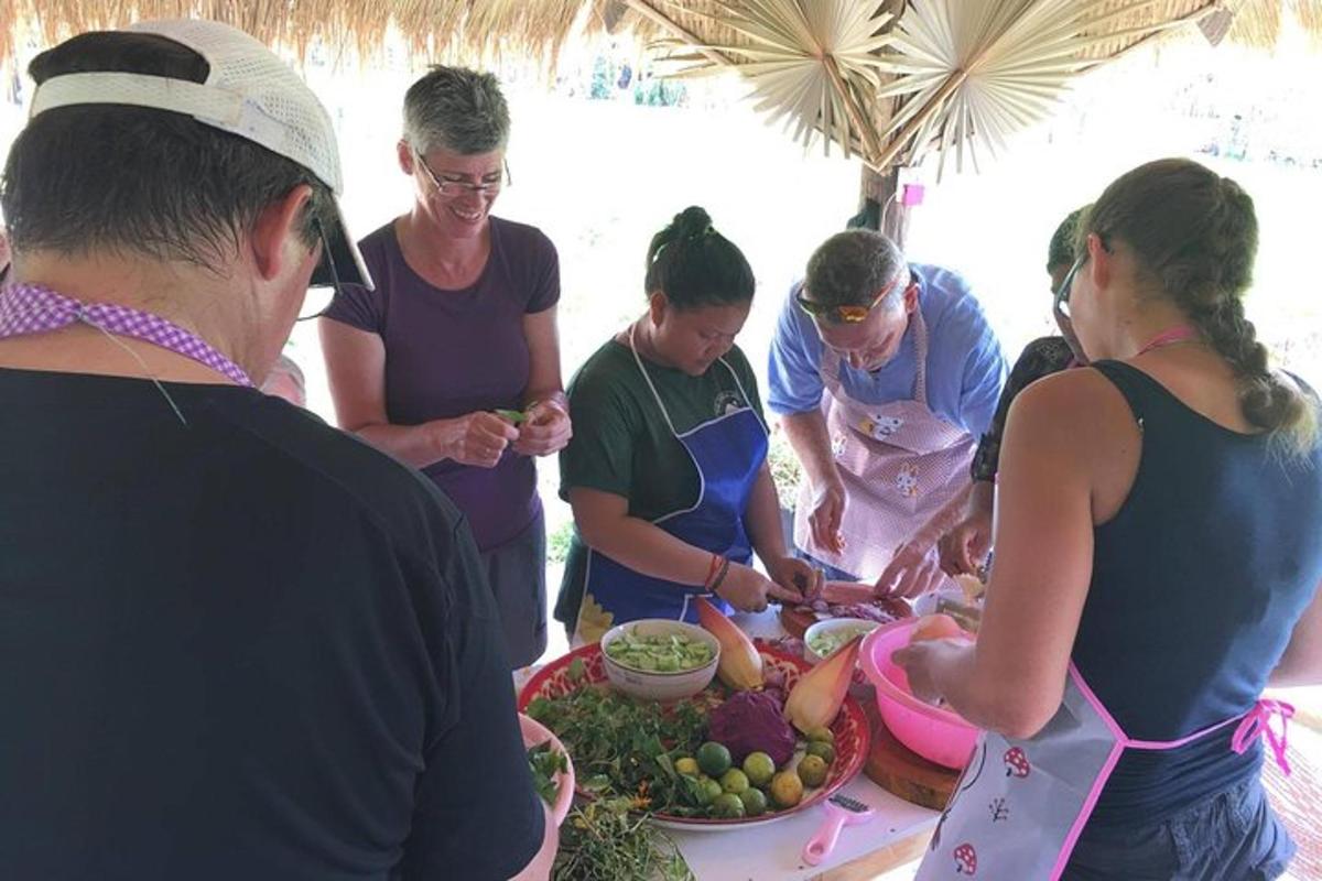 sekumpulan orang berdiri di sekeliling meja dengan makanan