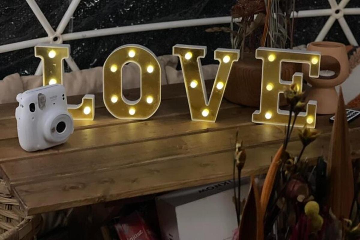 cedule s nápisem láska a světýlky na stole