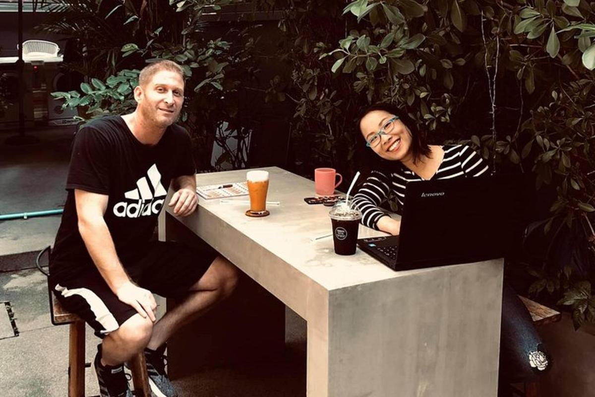 một người đàn ông và một người phụ nữ đang ngồi ở bàn với một chiếc máy tính xách tay