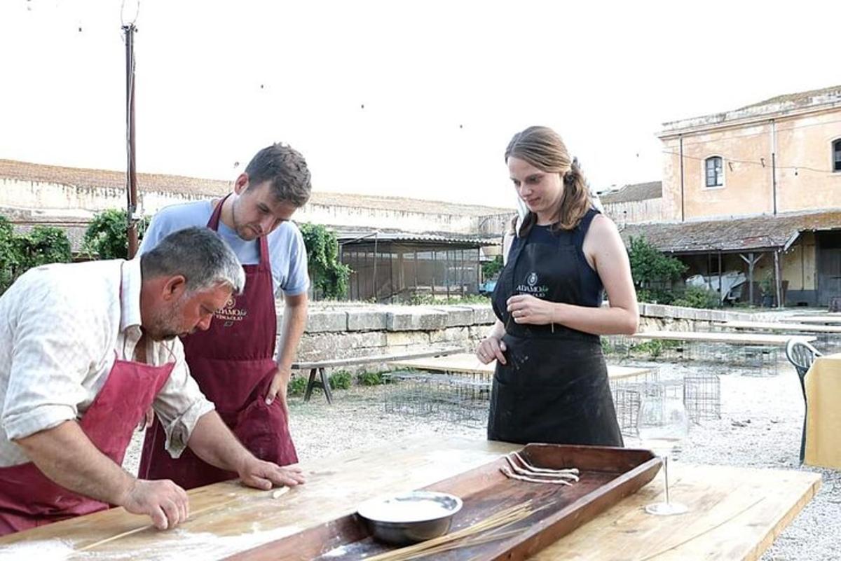 due uomini e una donna che preparano il cibo su un tavolo