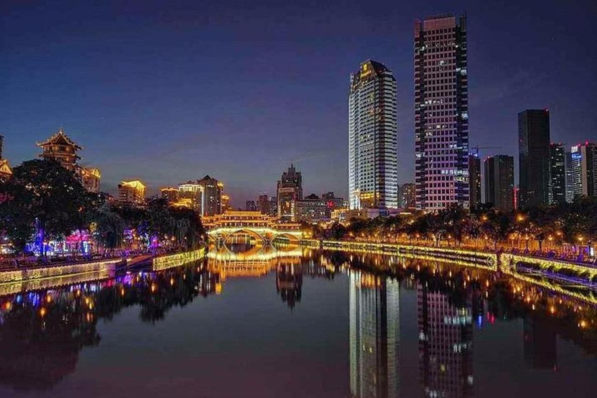a city skyline at night with a river and buildings