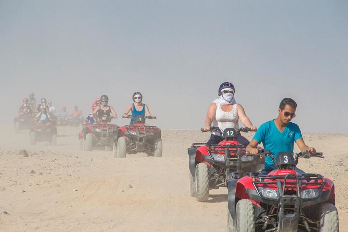 sekumpulan orang menunggang atv di dalam pasir