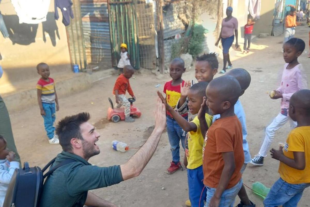 um homem dando um high five para um grupo de crianças