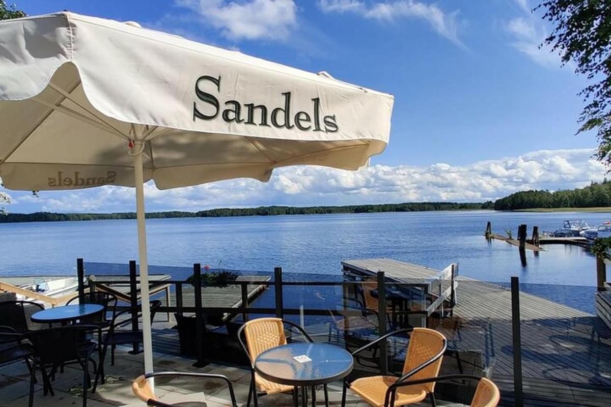 a table with chairs and an umbrella next to a lake
