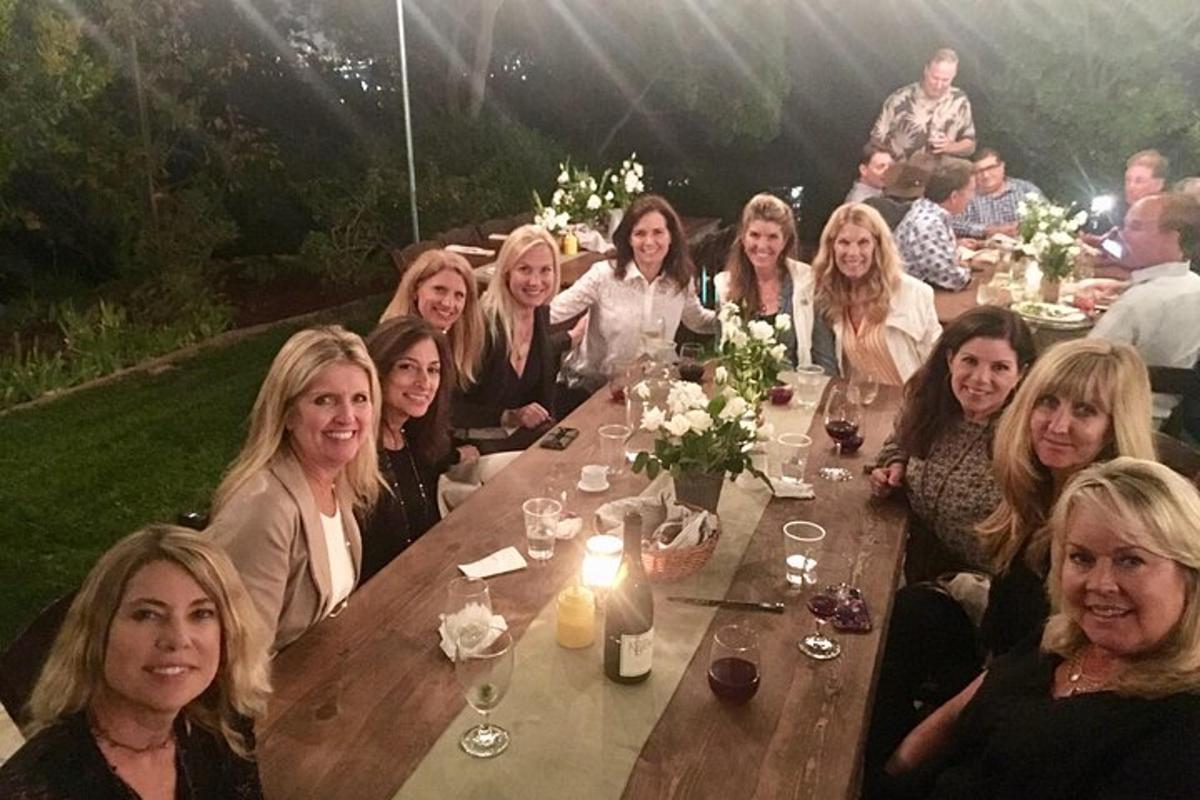 un gruppo di donne sedute a un lungo tavolo