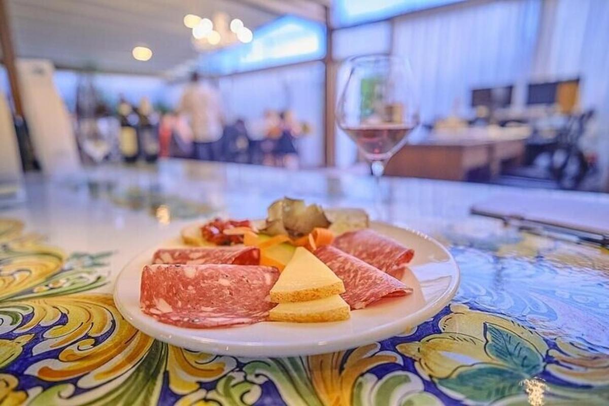 um prato de comida sobre a mesa com uma taça de vinho