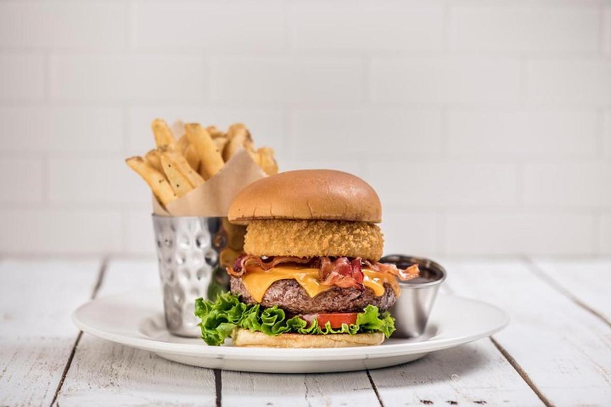 a cheeseburger on a plate with a basket of fries