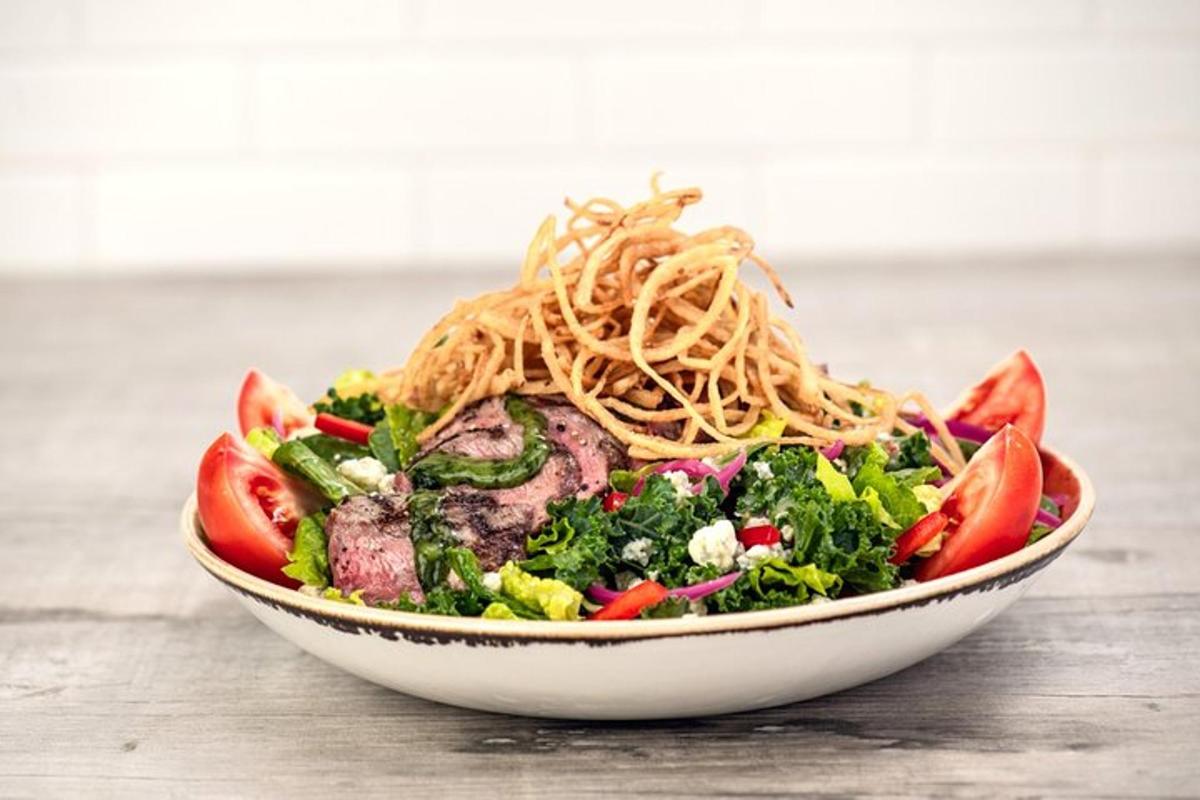 a bowl of food with noodles on top of a salad