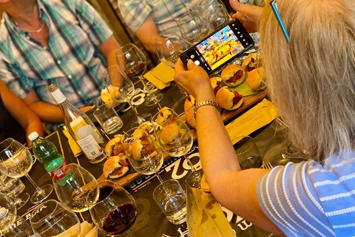 un gruppo di persone sedute al bar con bicchieri di vino