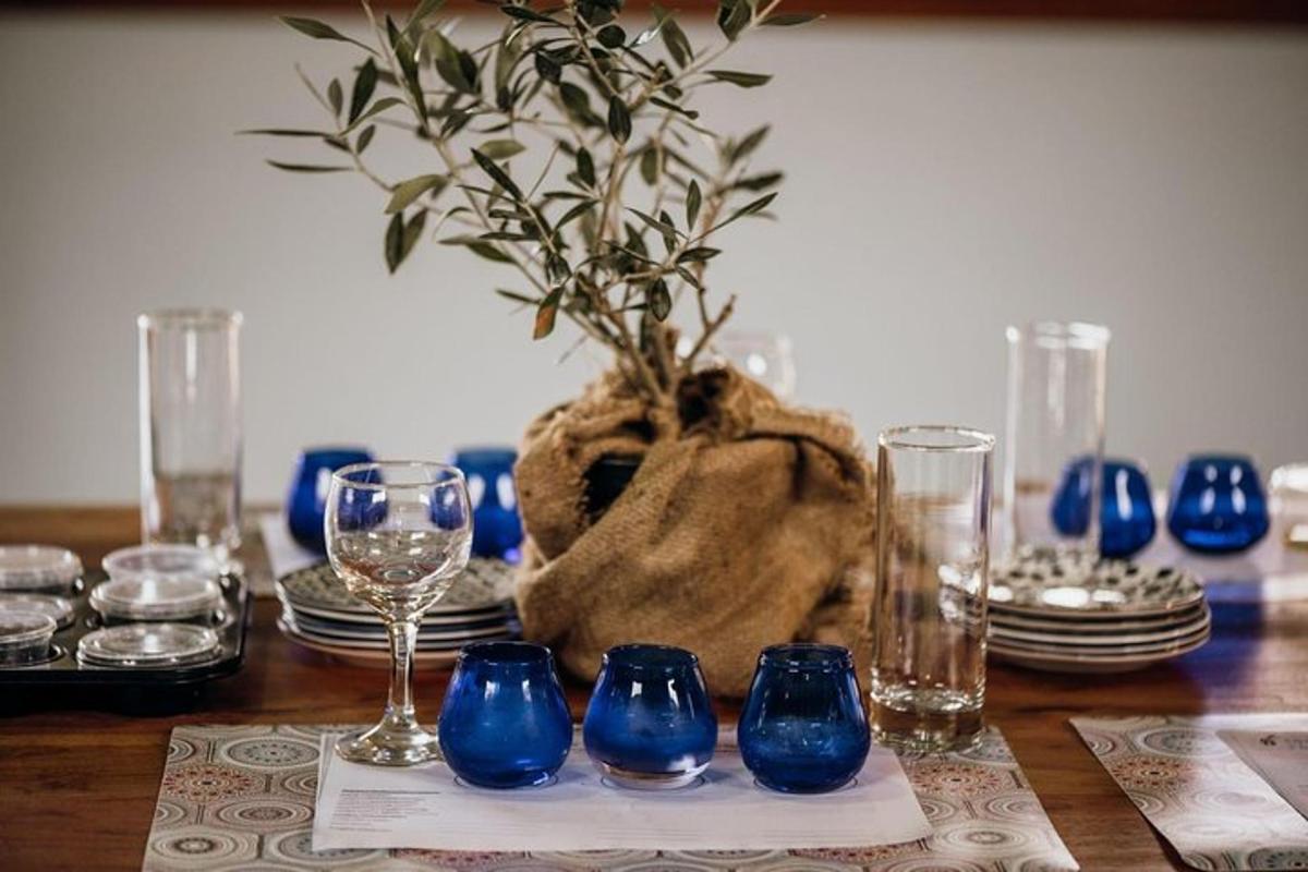 a table with blue glasses and a potted plant
