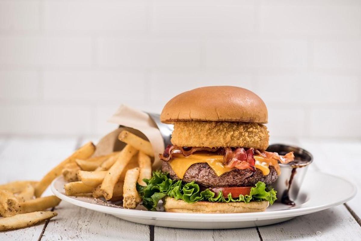 a plate with a hamburger and french fries on a table