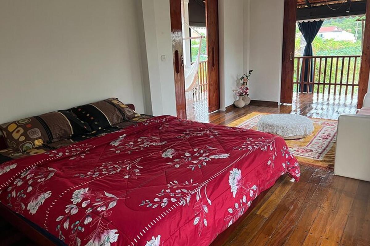 un letto rosso in una stanza con pavimento in legno