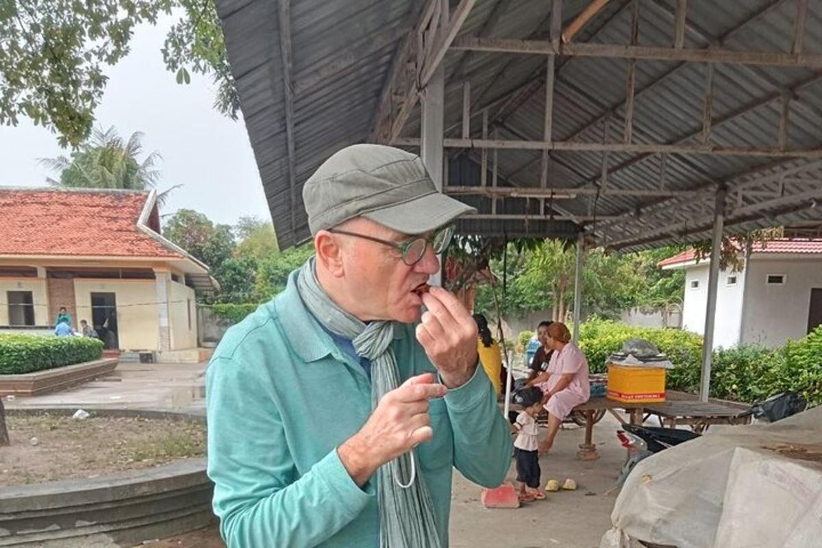 Starší muž kouří cigaretu pod stanem