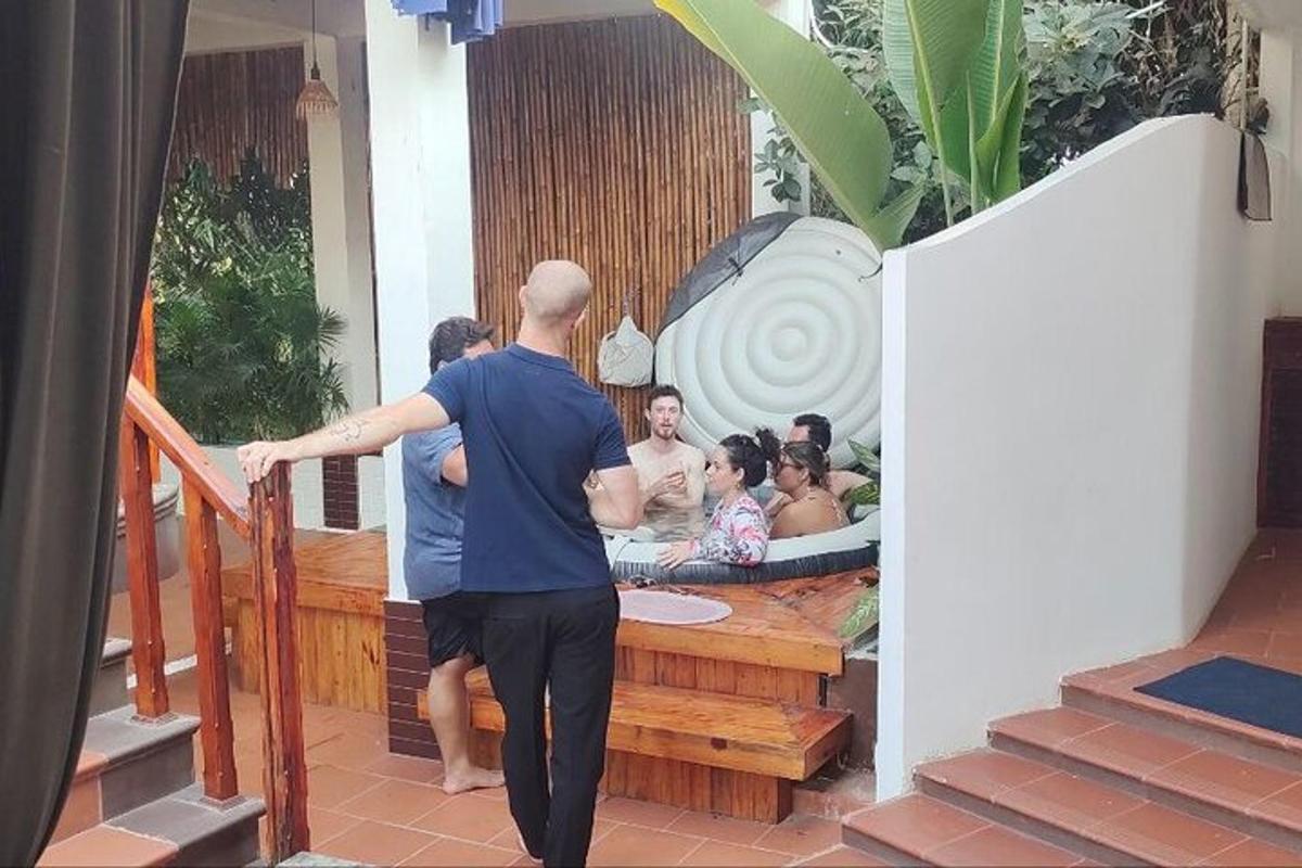 un uomo che entra in una vasca idromassaggio con un gruppo di persone