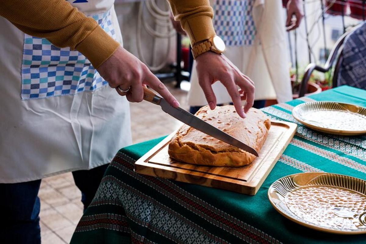 osoba krájející bochník chleba nožem