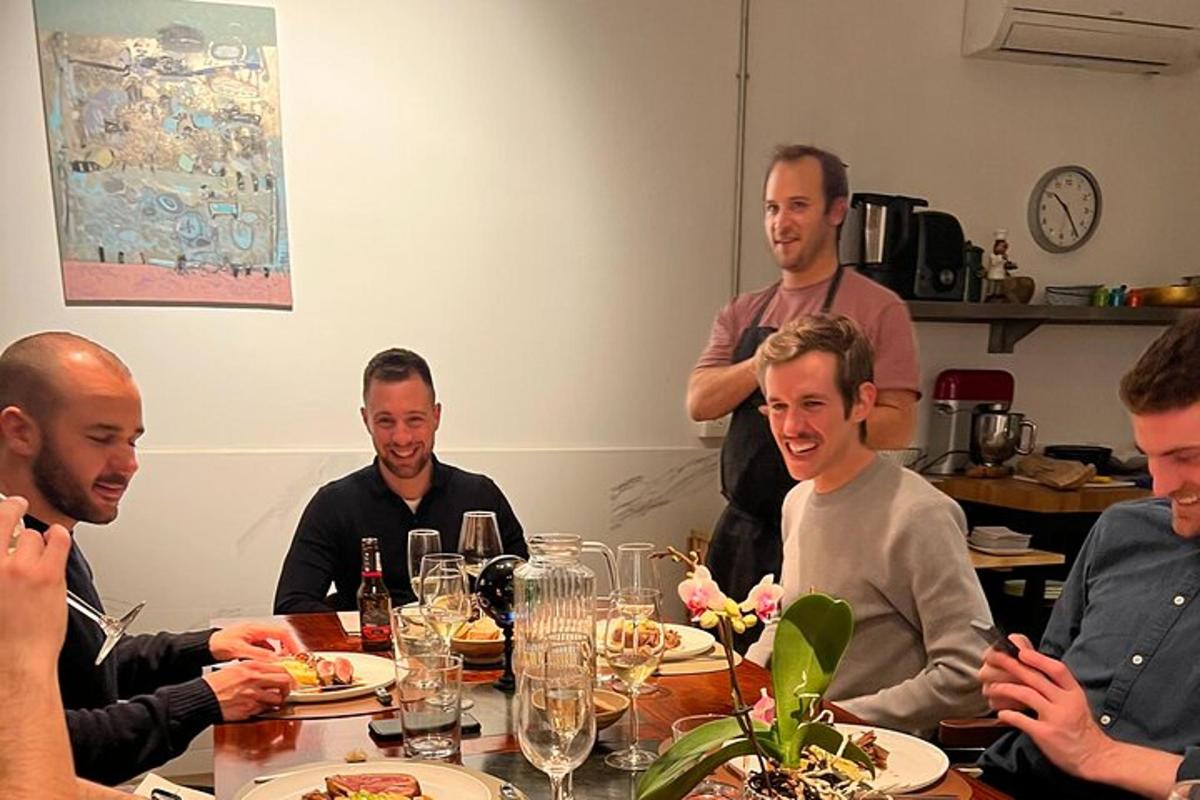 un gruppo di uomini seduti attorno a un tavolo che mangiano