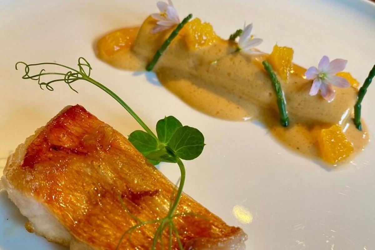 un piatto bianco con un pezzo di cibo con sopra dei fiori