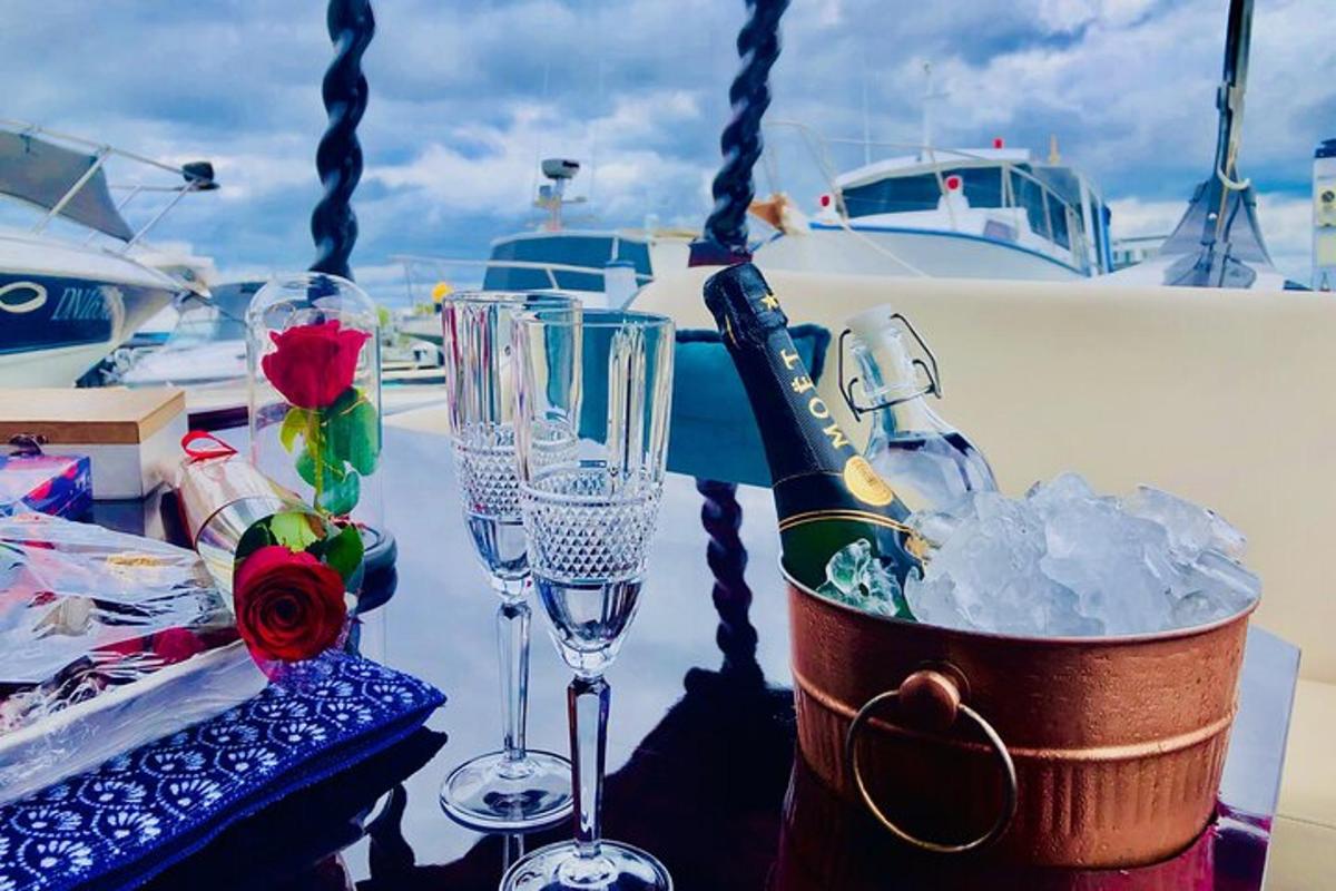 a table with glasses and a bottle of wine on a boat
