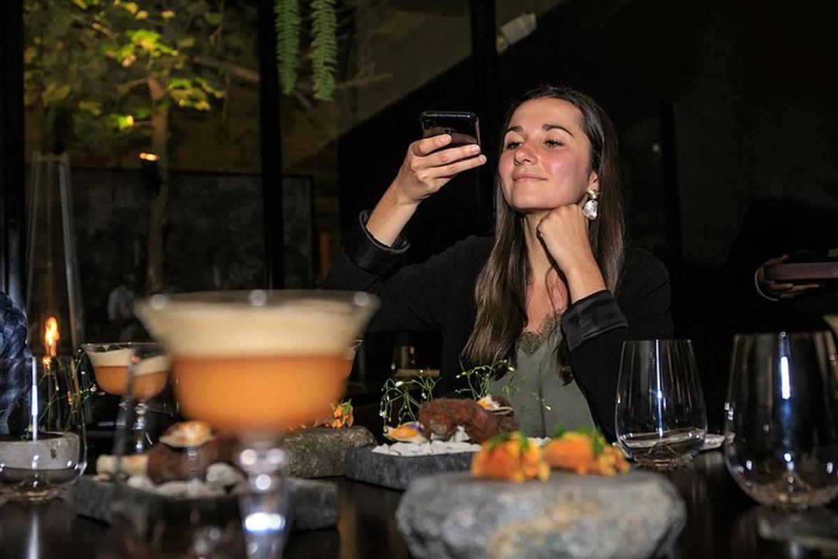 una donna seduta a un tavolo che scatta una foto con il suo cellulare
