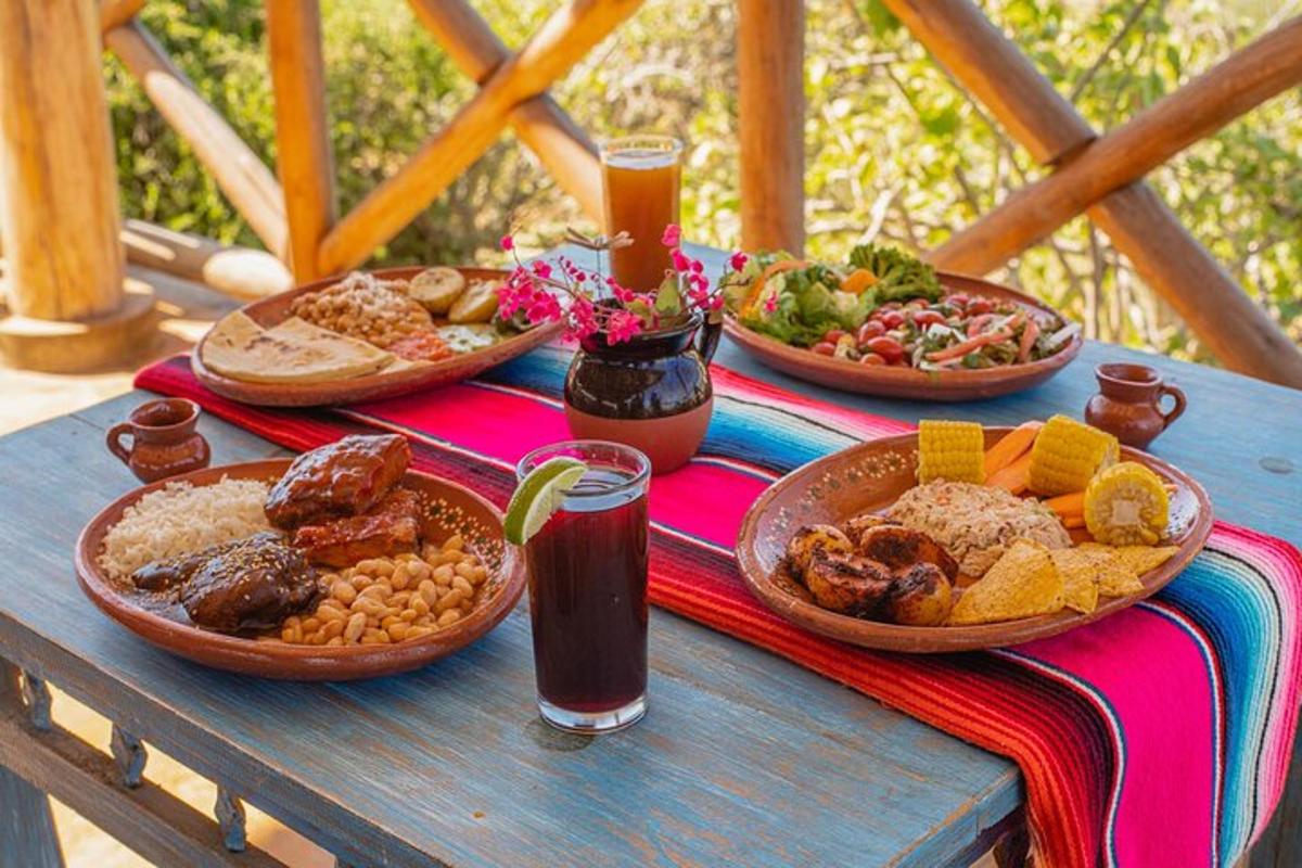 a picnic table with plates of food and drinks