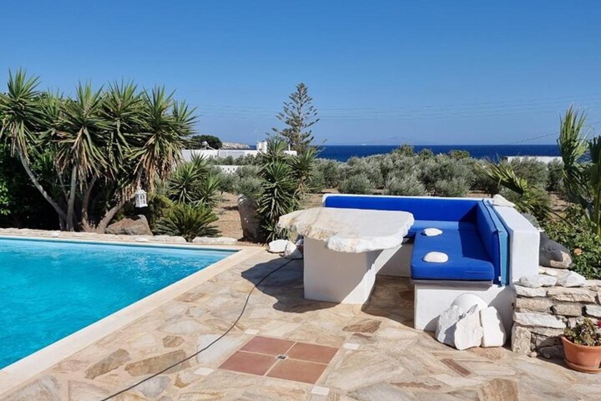 una villa con piscina e una panchina blu