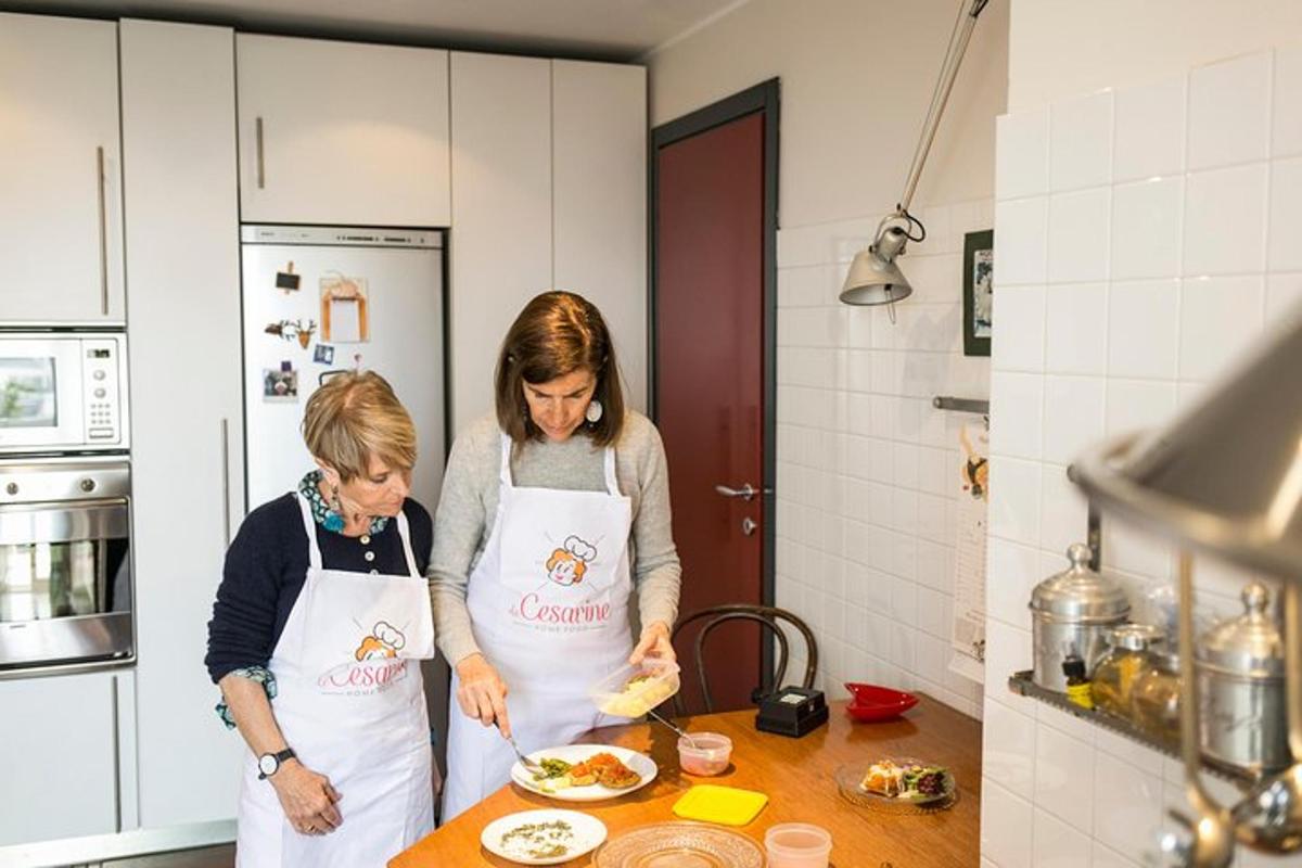 two women standing in a kitchen preparing food