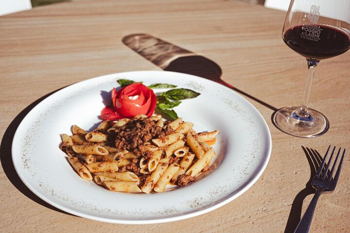 en tallerken med pasta på et bord med et glass vin