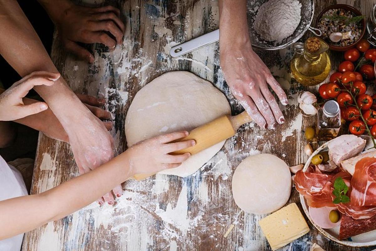 a group of people making a dough on a table