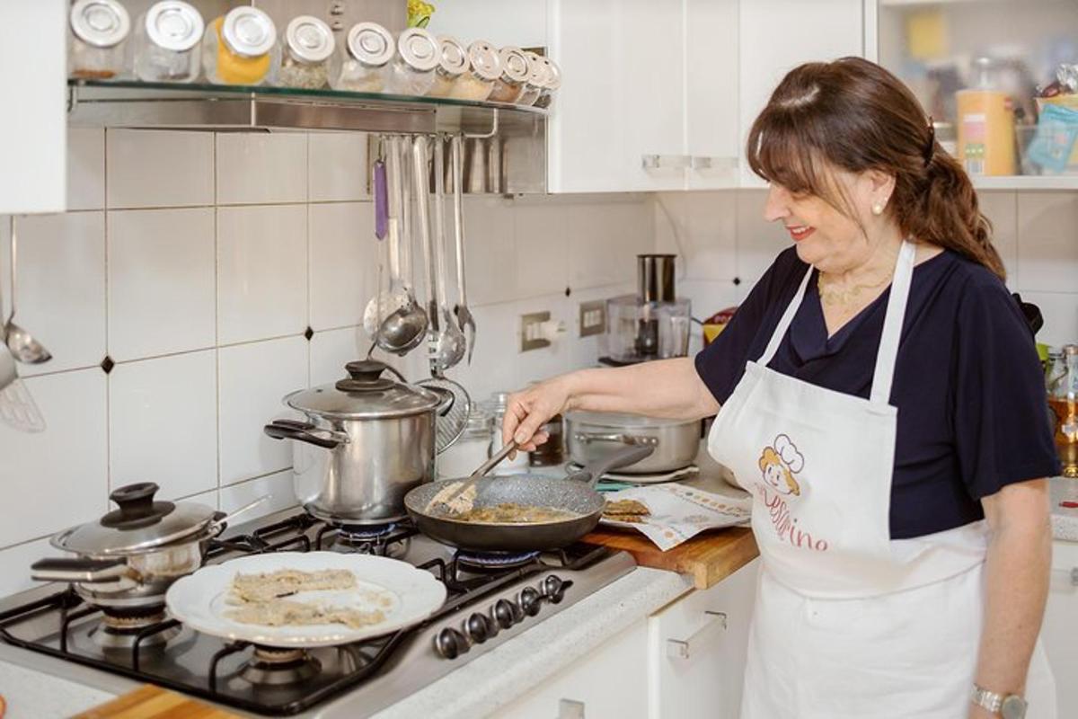 uma mulher na cozinha preparando comida em uma frigideira