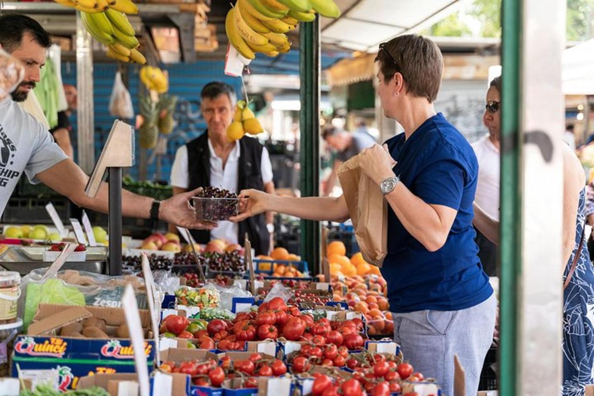 мужчина протягивает женщине корзину с фруктами на рынке