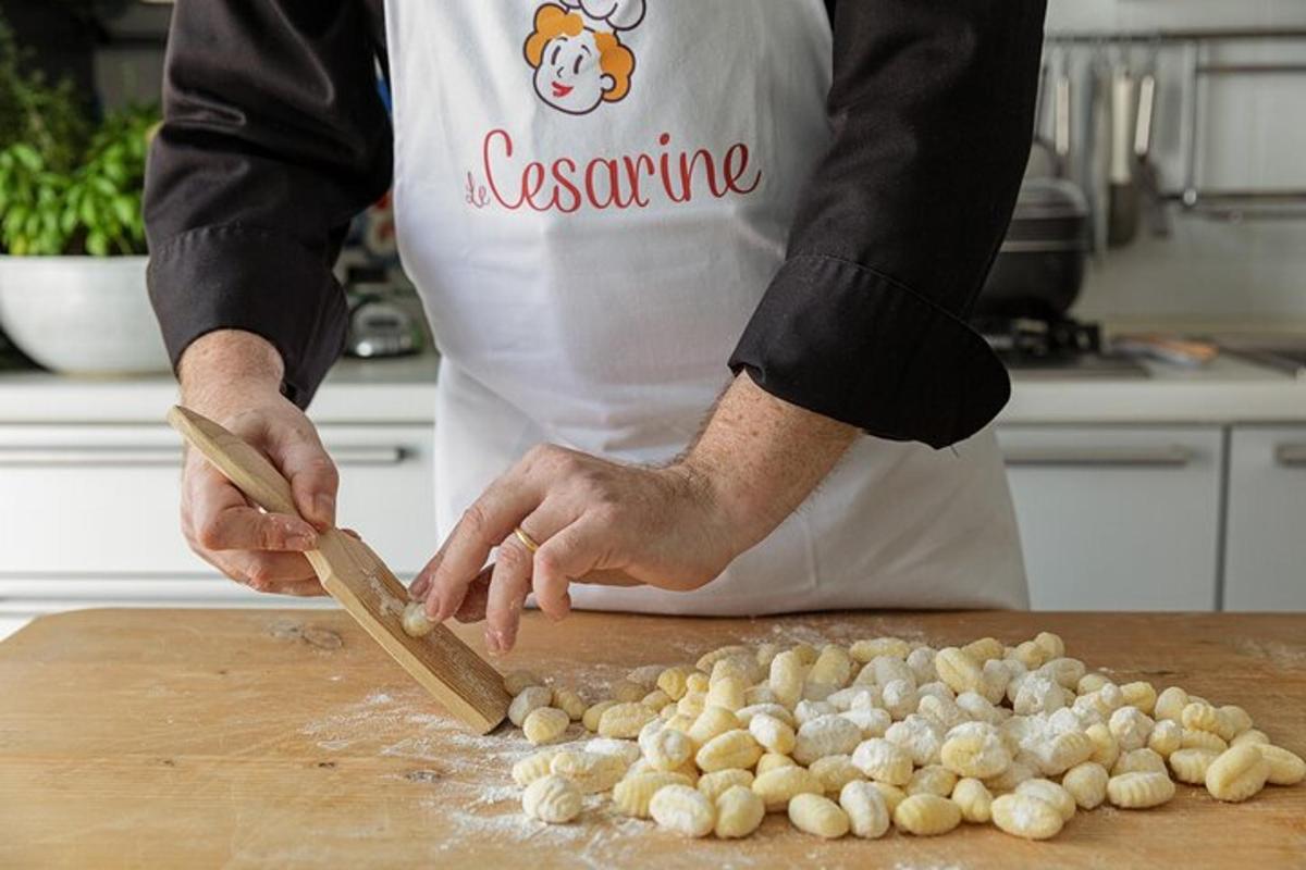 Un hombre en una cocina cortando ajo en una tabla de cortar.