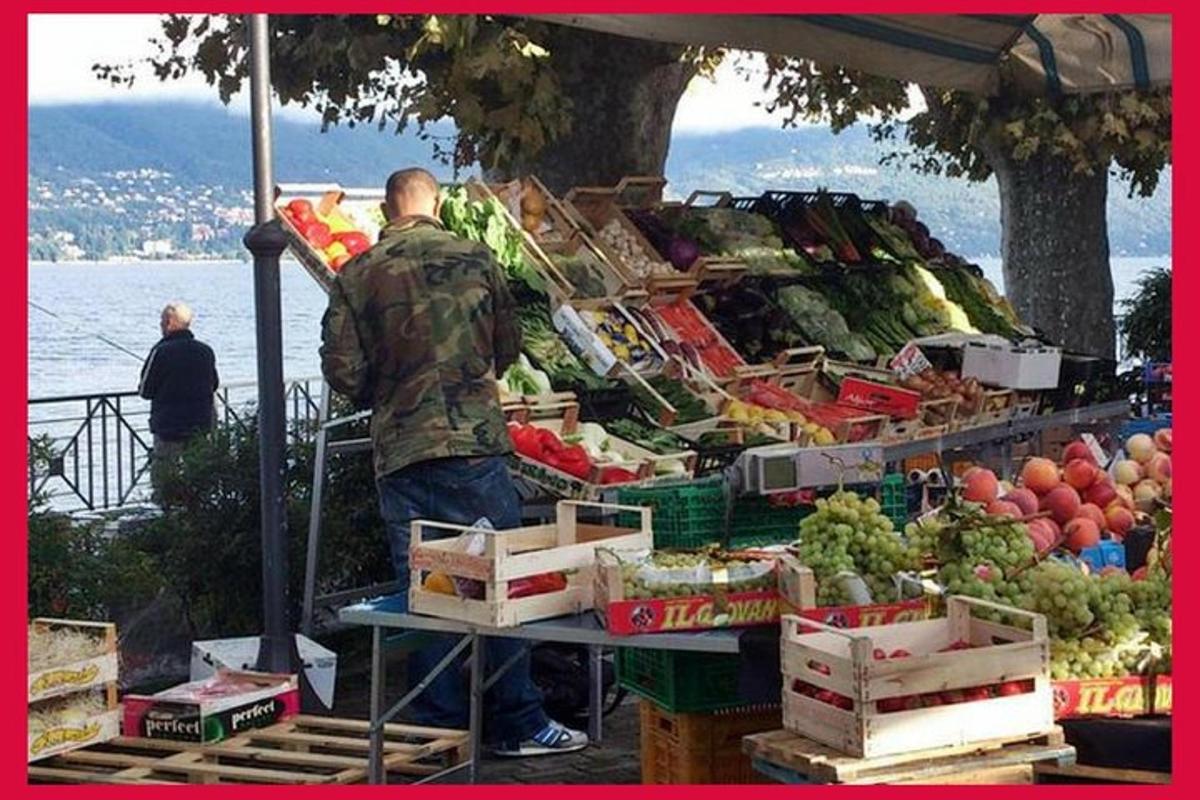 a man standing in front of a fruit and vegetable stand
