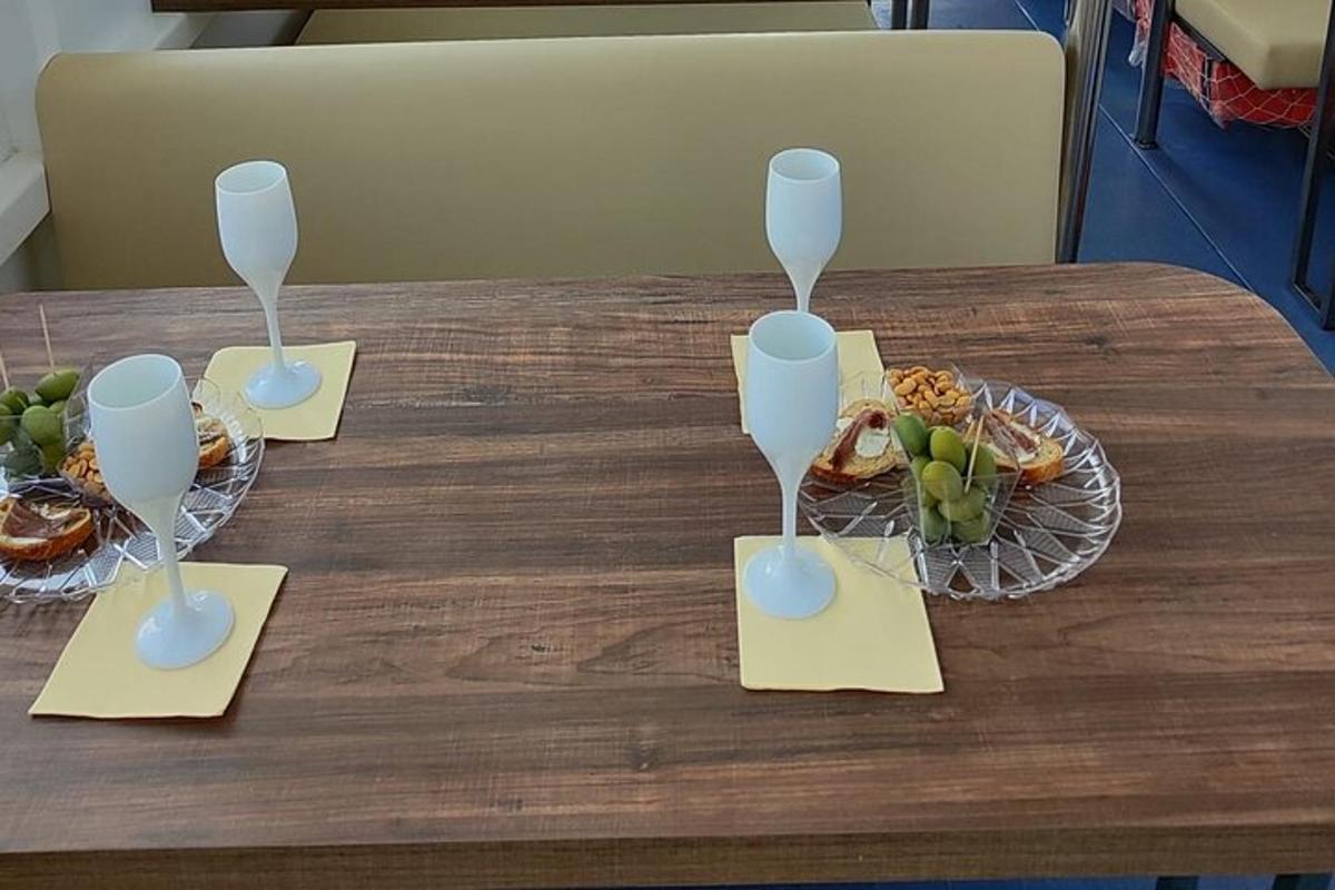 uma mesa com duas taças de vinho e uma tigela de frutas